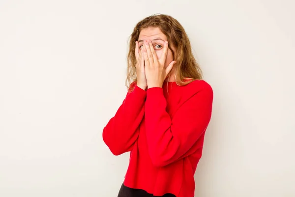 stock image Young caucasian woman isolated on white background blink through fingers frightened and nervous.