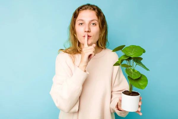Young Caucasian Woman Holding Plant Isolated Blue Background Keeping Secret — Stock Photo, Image