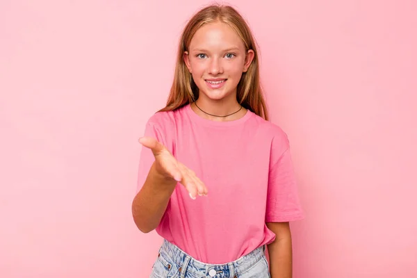 stock image Caucasian teen girl isolated on pink background stretching hand at camera in greeting gesture.