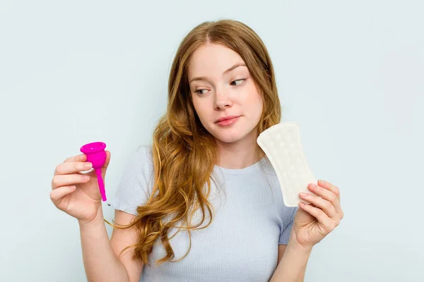 Junge Kaukasier Halten Menstruationstasse Und Damenserviette Isoliert Auf Blauem Hintergrund — Stockfoto