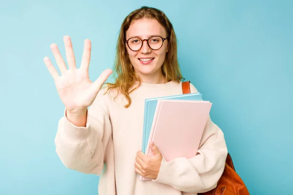 年轻的学生高加索女人在蓝色的背景上孤立无援 笑容满面 带着五号手指 — 图库照片