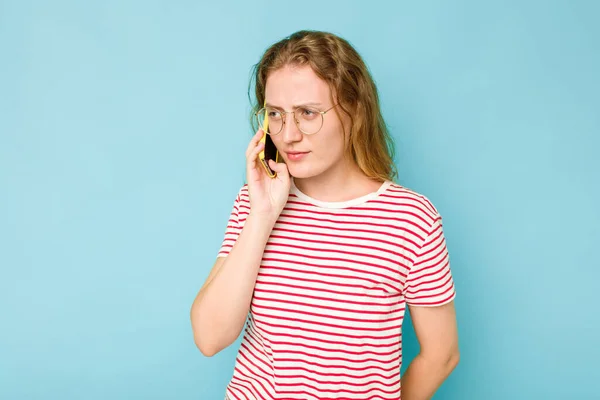 Mavi Arka Planda Cep Telefonu Tutan Beyaz Bir Kadın Var — Stok fotoğraf