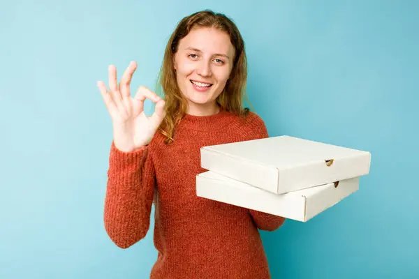 年轻的高加索女人拿着用蓝色背景隔开的比萨饼盒 开心而自信地摆出一副不错的姿势 — 图库照片