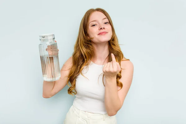 Молодая Белая Женщина Держащая Банку Водой Голубом Фоне Указывая Пальцем — стоковое фото