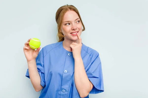 Giovane Fisioterapista Caucasico Possesso Una Palla Tennis Isolata Sfondo Blu — Foto Stock