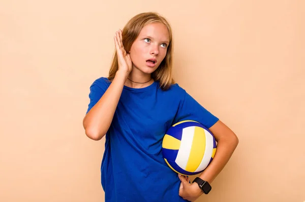 Маленька Біла Дівчинка Грає Волейбол Ізольовано Бежевому Фоні Намагаючись Слухати — стокове фото