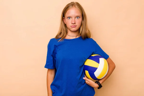 Маленькая Кавказская Девочка Играет Волейбол Изолированный Бежевом Фоне Пожимает Плечами — стоковое фото