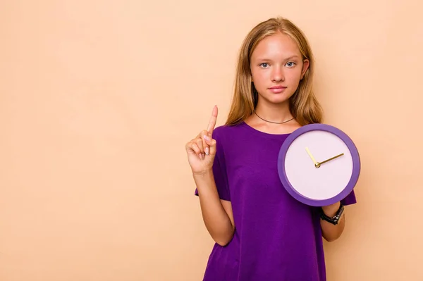 Little Caucasian Girl Holding Clock Isolated Beige Background Showing Number — Stock Photo, Image