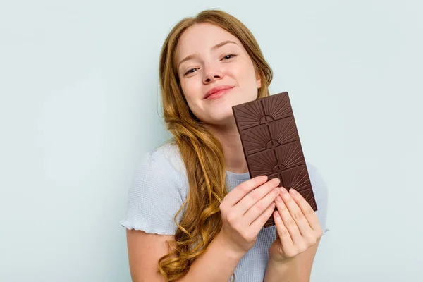 青い背景に隔離されたチョコレートを保持若い白人女性 — ストック写真