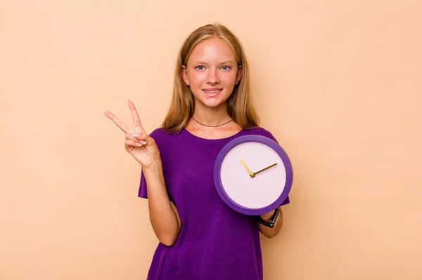 Niña Caucásica Sosteniendo Reloj Aislado Sobre Fondo Beige Mostrando Número — Foto de Stock