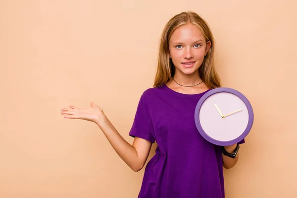 Menina Caucasiana Segurando Relógio Isolado Fundo Bege Mostrando Espaço Cópia — Fotografia de Stock