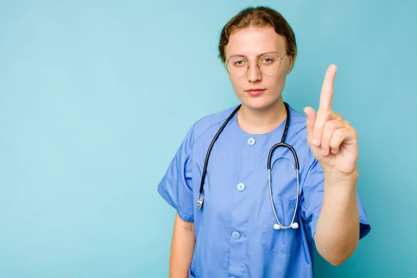 Joven Enfermera Caucásica Aislada Sobre Fondo Azul Mostrando Número Uno — Foto de Stock