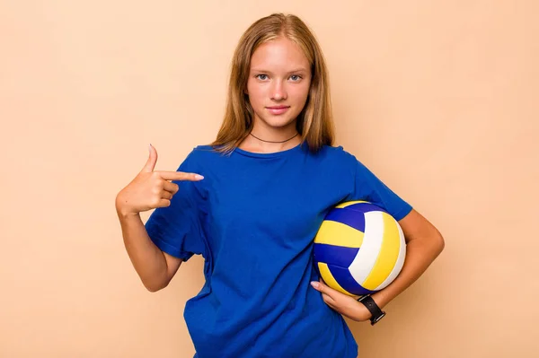 小さなCaucasian女の子遊びバレーボール孤立した上ベージュ背景人指していますに手によってシャツコピースペース 誇りと自信 — ストック写真