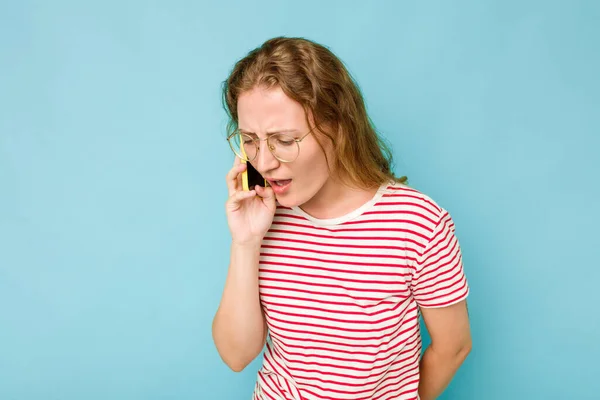 Joven Mujer Caucásica Sosteniendo Teléfono Móvil Aislado Sobre Fondo Azul — Foto de Stock