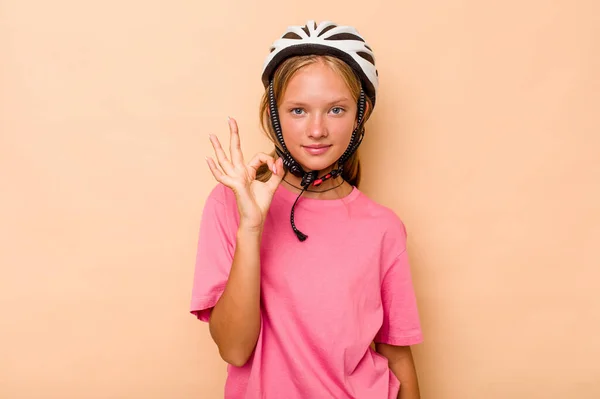 一个带着自行车头盔的高加索小女孩 带着米色背景的隔离 快乐而自信地做出了一个好的姿态 — 图库照片