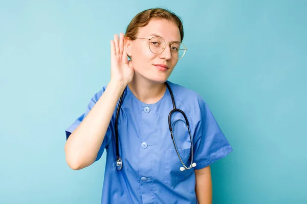 Ung Sjuksköterska Kaukasisk Kvinna Isolerad Blå Bakgrund Försöker Lyssna Ett — Stockfoto