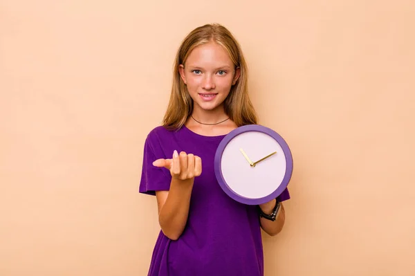 Little Caucasian Girl Holding Clock Isolated Beige Background Pointing Finger — Stock Photo, Image