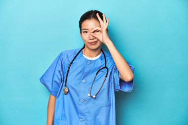 Steteskoplu Asyalı hemşire, stüdyo fotoğrafçısı, heyecanlı..