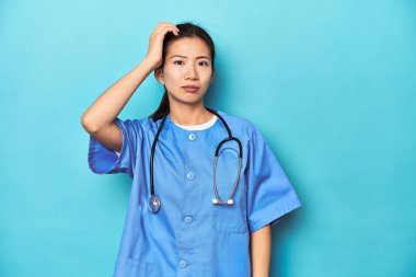 Steteskoplu Asyalı hemşire, stüdyo fotoğrafı, şok geçirdiği için önemli bir toplantıyı hatırladı..