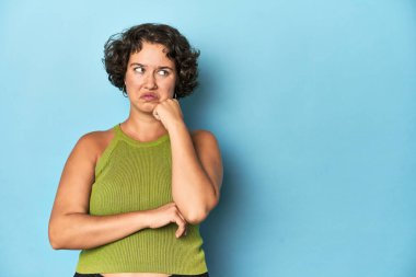 Kısa saçlı, üzgün ve düşünceli genç, beyaz bir kadın fotokopi odasına bakıyor..