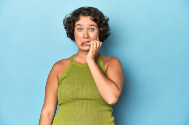 Kısa saçlı, tırnaklarını yiyen, gergin ve endişeli bir beyaz kadın..