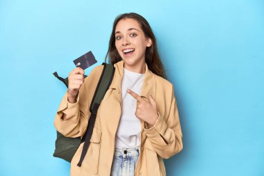 Sırt çantası ve kredi kartı mavi olan genç bir gezgin kadın..