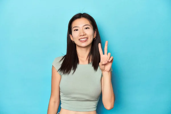 Yazın Yeşil Bluzlu Asyalı Kadın Stüdyo Arkaplanı Neşeli Tasasız Parmaklarıyla — Stok fotoğraf