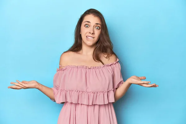 Young Woman Wearing Pink Dress Blue Studio Backdrop Confused Doubtful — Stock Photo, Image