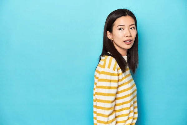Asiatisk Kvinde Stribet Gul Sweater Ser Til Side Smilende Munter - Stock-foto