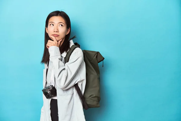 年轻的亚洲旅行者准备捕捉冒险 带着怀疑和怀疑的表情侧视 — 图库照片