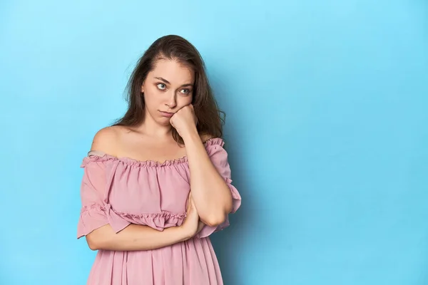Mujer Joven Con Vestido Rosa Fondo Estudio Azul Que Siente — Foto de Stock