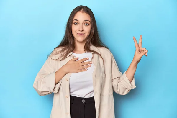 Snygg Ung Kvinna Overshirt Blå Bakgrund Sätta Handen Bröstet — Stockfoto