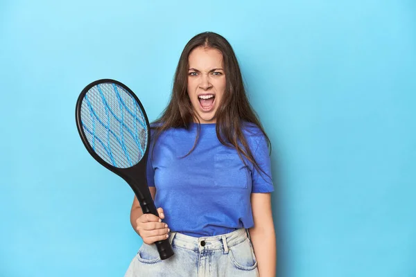 非常に怒って攻撃的な叫ぶ青い背景に電気バグバッパーを持つ女性 — ストック写真