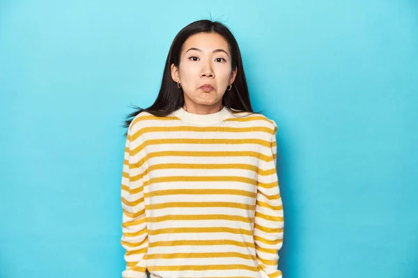 Asian Woman Striped Yellow Sweater Shrugs Shoulders Open Eyes Confused — Stock Photo, Image