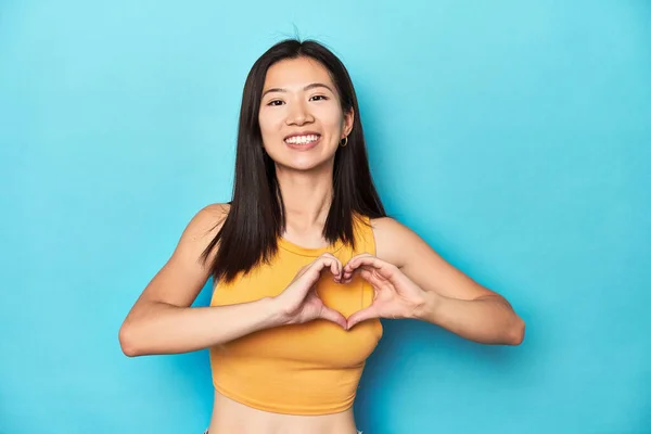 Azjatka Letniej Żółtej Bluzce Ustawienie Studio Uśmiech Pokazując Kształt Serca — Zdjęcie stockowe