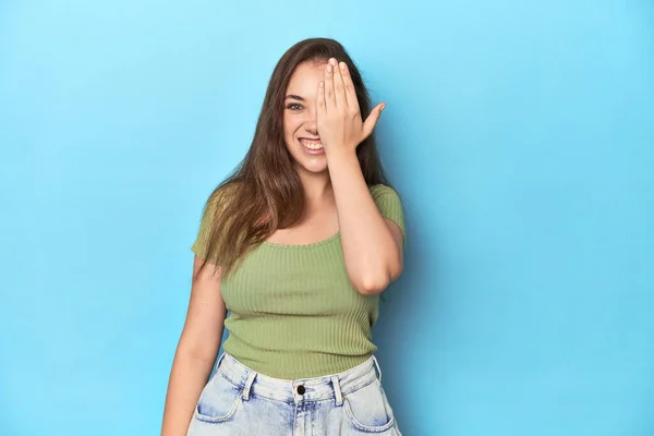 Jonge Blanke Vrouw Een Groene Top Een Blauwe Achtergrond Plezier — Stockfoto