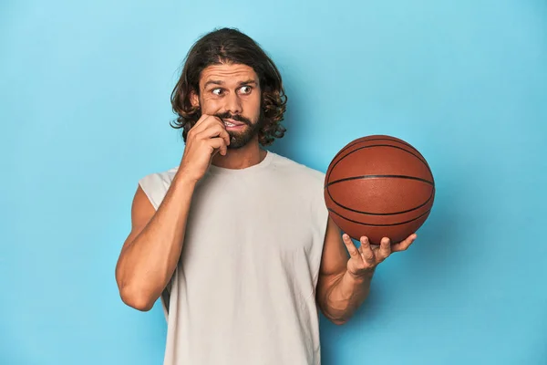 Vousatý Muž Basketbalem Modrém Studiu Kouše Nehty Nervózní Velmi Úzkostlivý — Stock fotografie