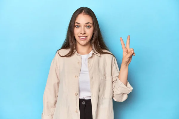 Stilig Ung Kvinne Overskjorte Blå Bakgrunn Gledelig Bekymringsløs Viser Fredssymbol – stockfoto