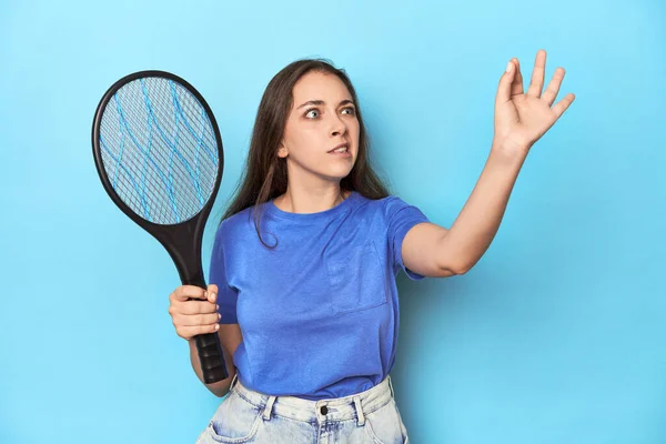 青いスタジオで電気蚊を抱えている女性 — ストック写真