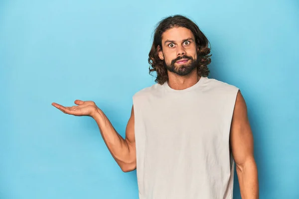 Bearded Man Tank Top Blue Backdrop Impressed Holding Copy Space — Stock Photo, Image