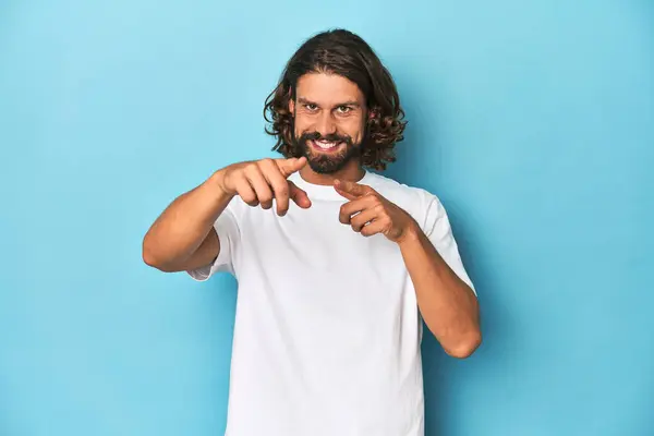 白いシャツのひげ付き男 指で前方に指を向ける青い背景 — ストック写真