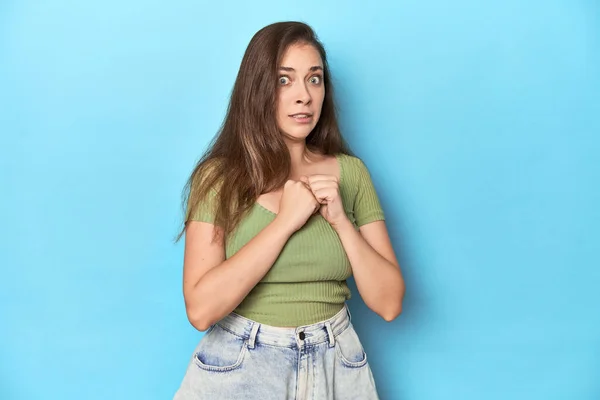 Mavi Bir Arka Planda Yeşil Bluzlu Genç Beyaz Kadın Korkmuş — Stok fotoğraf