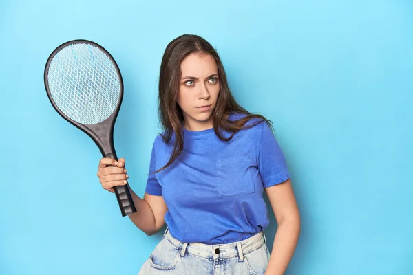 青いスタジオで電気蚊を抱えている女性 — ストック写真