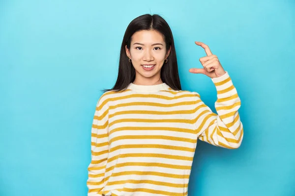 身穿条纹黄色毛衣的亚洲女人 手握食指 面带微笑 信心十足 — 图库照片