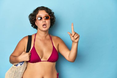 Plaj çantalı, bikinili genç bir kadının bir fikri var, ilham verici bir kavram..