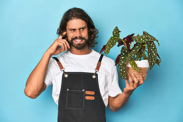 Sakallı Uzun Saçlı Bahçıvan Elleriyle Kulaklarını Kapatan Bir Bitki Tutuyor — Stok fotoğraf