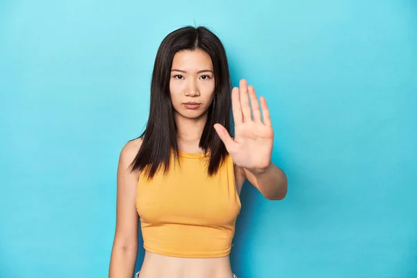 Azjatka Letniej Żółtej Bluzce Ustawienie Studio Stojąc Wyciągniętą Ręką Pokazując — Zdjęcie stockowe