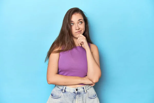 Fashionable Young Woman Purple Top Blue Background Thinking Looking Being — Stock Photo, Image