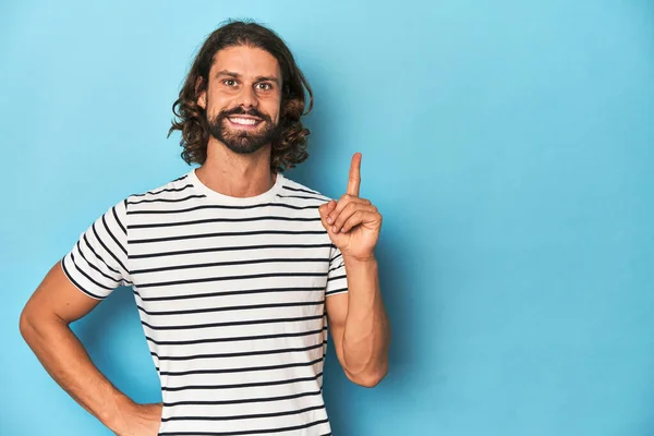 Bearded Man Striped Shirt Blue Backdrop Showing Number One Finger — Stock Photo, Image