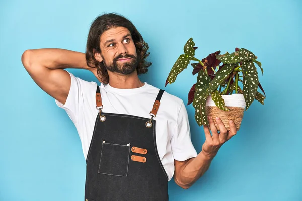 Long Haired Gardener Beard Holding Plant Touching Back Head Thinking — Stock Photo, Image
